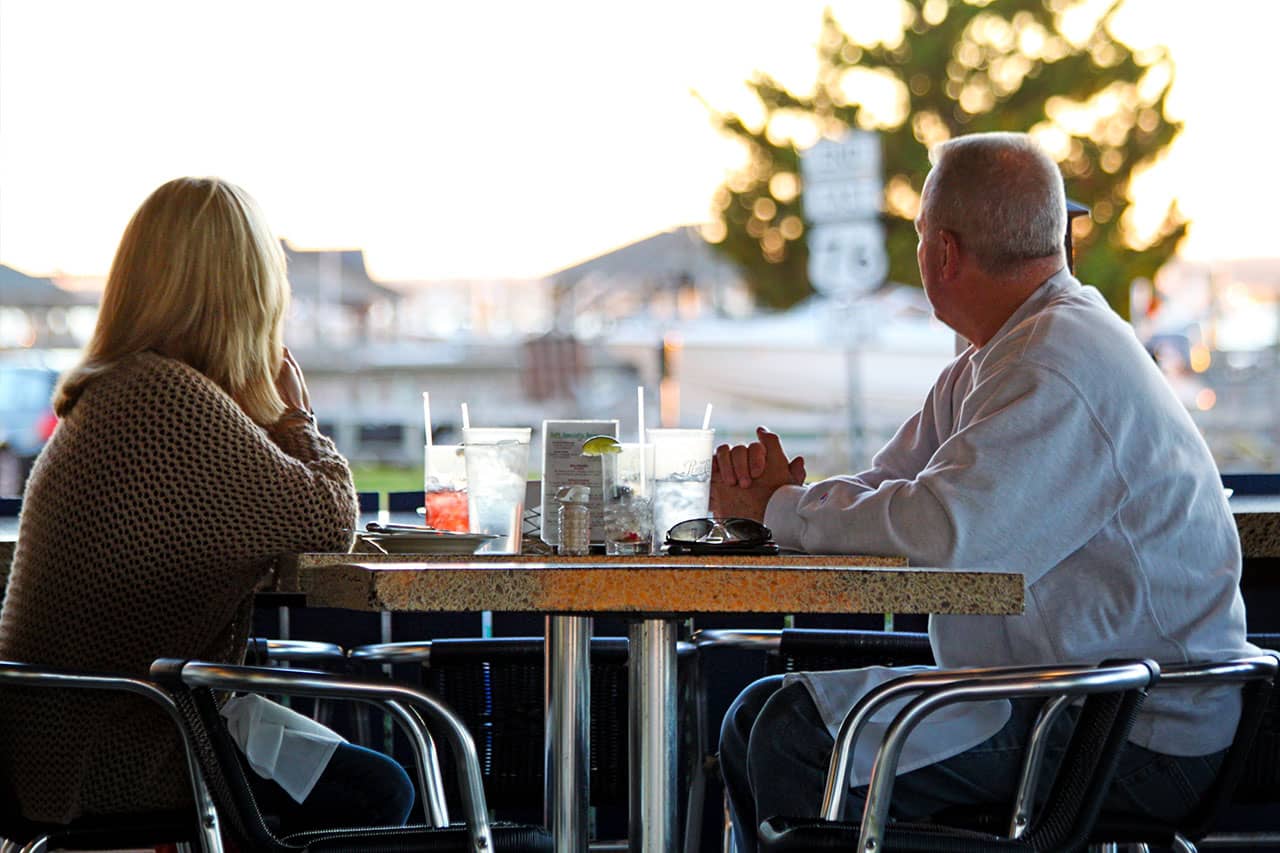 A couple sits on the patio of South Beach Grill at sunset